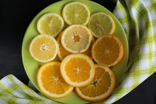 Juicy, Sliced Citrus Fruits Lemon, Orange Background On Plate Near Green Napkin. Top View