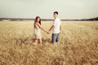 © Kotangens - love couple walking in field holding hands