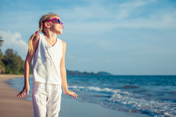 Little girl  dancing on the beach at the day time.