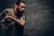 © Fxquadro - Tattooed bearded male sits on a chair.