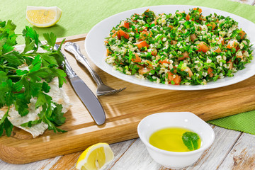 Poster - Tabbouleh parsley salad on white platter on chopping board