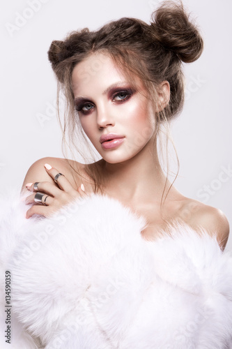 Naklejka dekoracyjna Beautifful european brunet woomen with gloss clean healfy skin, glooss shiny pastel pink lipstik and with trendy fashion hairstyle in white fluffy fur coat