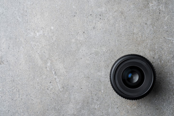 Modern camera lens on gray stone table