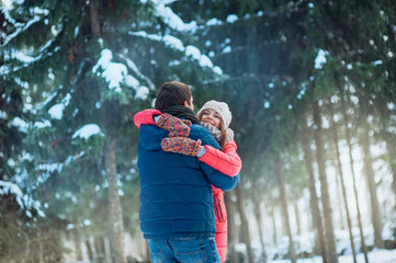 woman and man having fun in winter forest