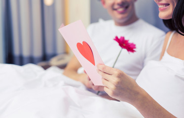 Poster - close up of couple in bed with postcard and flower