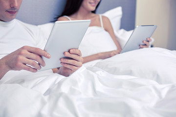 Poster - smiling couple in bed with tablet pc computers