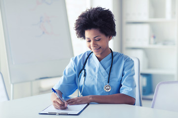 Poster - happy female doctor or nurse writing to clipboard