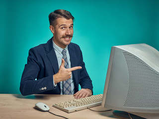 Wall Mural - Portrait of cheerful young businessman sitting with computer