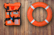 Life buoy and life jacket hanging on wooden wall for emergency response when people sinking to water almost place near pool and beach