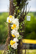 Garland Of White And Yellow Flowers Hangs On Osier Wedding Altar