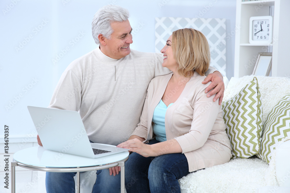 Grandparents using laptop at home