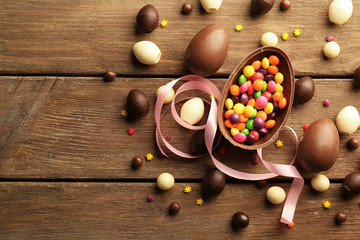 Sticker - Chocolate Easter eggs and sweets on brown wooden background