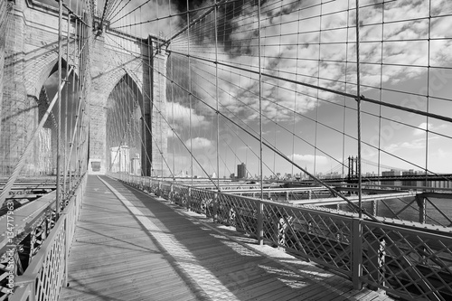 Naklejka dekoracyjna Empty Brooklyn Bridge footpath in a sunny day, New York in black and white