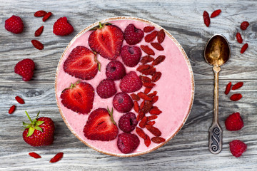 Wall Mural - Pink acai, maca powder smoothie bowl  topped with sliced strawberries, raspberries and goji berries. Flat lay, copy space. Valentines Day superfood aphrodisiac meal