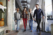 © Mint Images - Two young men and two young women walking along a sidewalk, smiling.