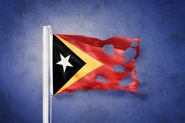 Wall Mural - Torn flag of East Timor flying against grunge background
