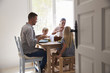 © Monkey Business - Family eating at table in sunlit room