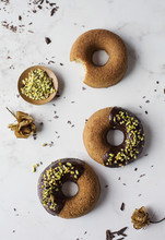 Donuts With Chocolate And Pistachios On Marble Table