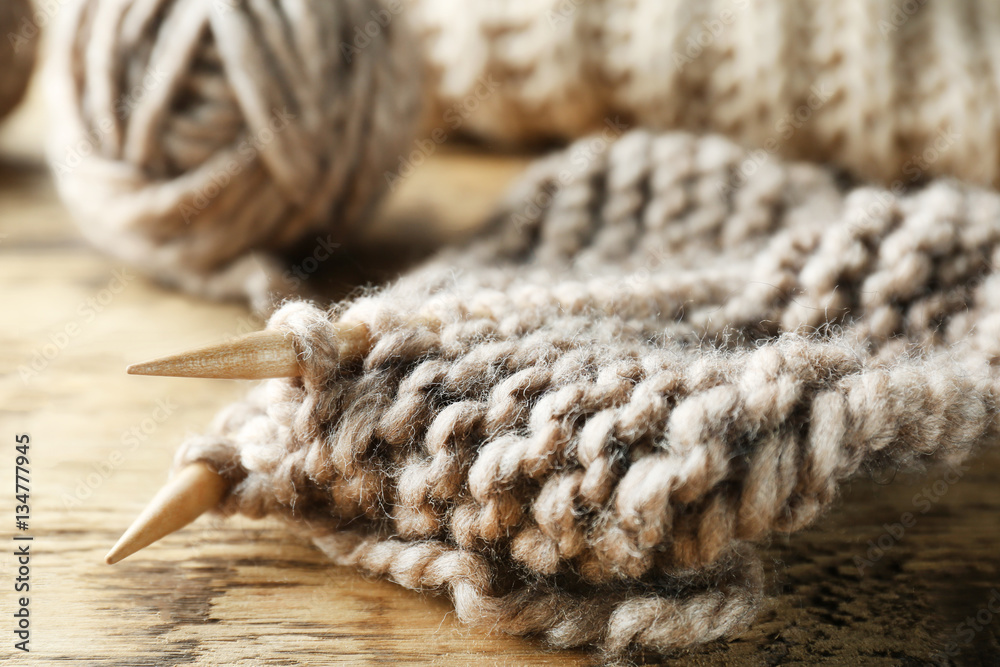 Knitting yarn and needles on wooden background, closeup