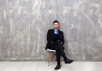 Wall Mural - Young man waiting for job interview on grey textured background