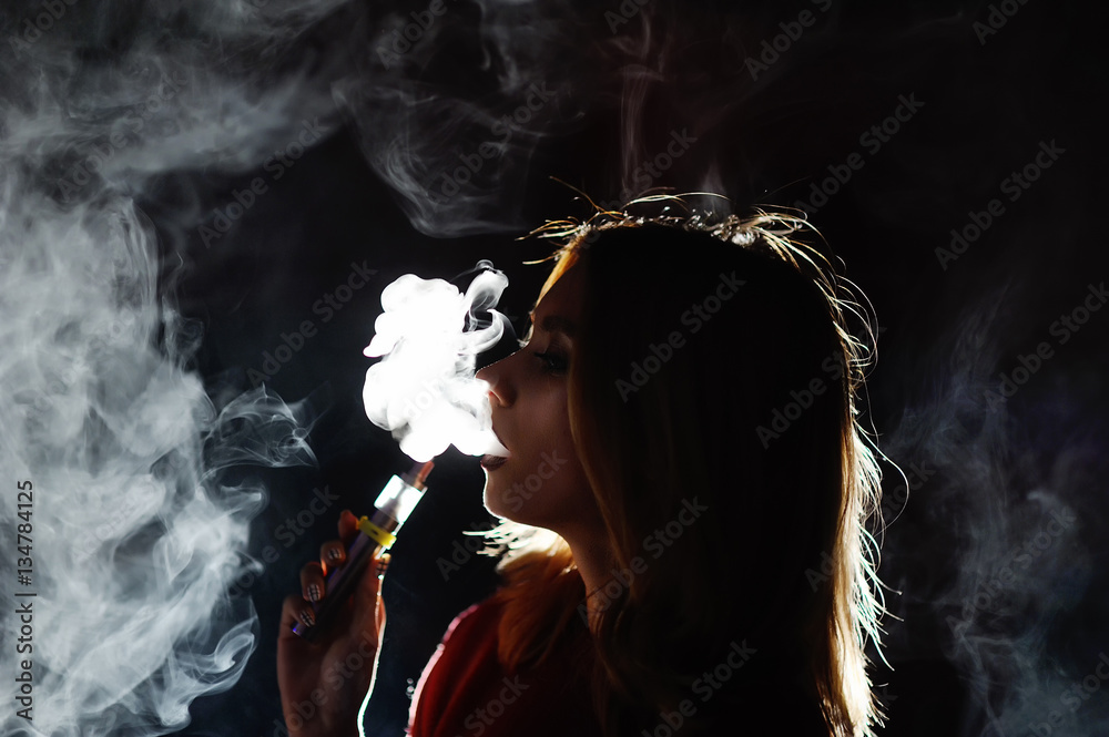 pretty girl viper smoke e-cigarette in a nightclub Stock Photo