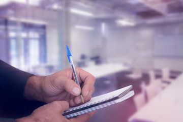 Canvas Print - Composite image of close up of man writing in spiral book