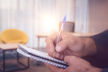 Canvas Print - Composite image of close up of man writing in spiral book