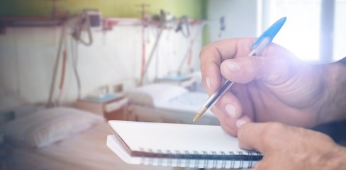 Canvas Print - Composite image of close up of man writing in notepad