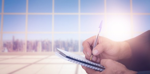 Canvas Print - Composite image of close up of man writing in spiral book