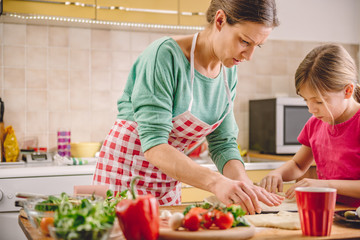 Wall Mural - Mother and daughter preparing pizza