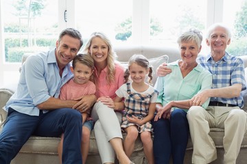 Multi generation family sitting on sofa in living room