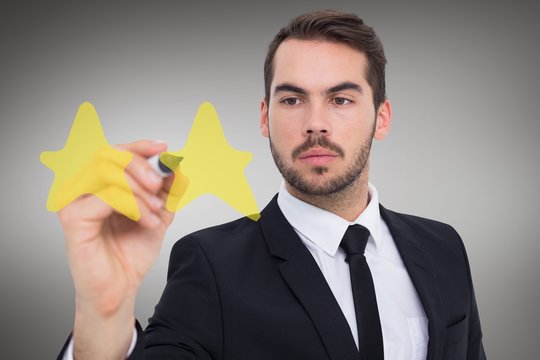 Composite image of focused businessman writing with marker