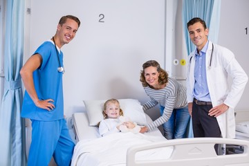 Canvas Print - Portrait of doctors, patient and woman in hospital room