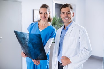 Two doctors standing with patients x-ray in hospital corridor