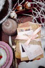 Top view of a table with dread and cookies baskets  candles, two chairs covered  white fur on the background. Picnic in the winter forest