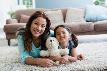 Sticker - Portrait of happy mother and daughter lying on rug