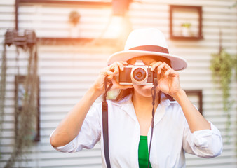 Portrait of a photographer covering her face with the camera. Greenery Tone 2017