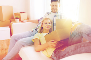 happy couple with big cardboard boxes at new home