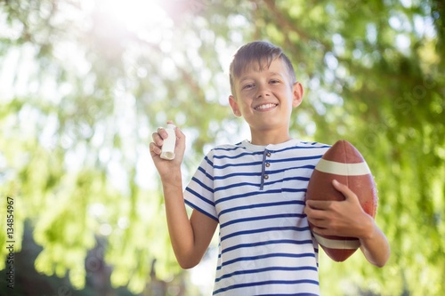 Plakat Chłopiec trzyma inhalator astmy i piłkę do rugby