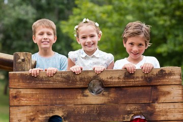 Wall Mural - Kids standing on a playground ride in park