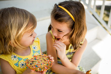 Two Young Girls Sharing A Cookie, Close Up 