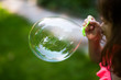 © Sarah Rypma - Young girl blowing soap bubble