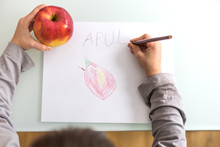 Hands Of Child Drawing And Writing Apple 