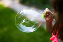Young Girl Blowing Soap Bubble 