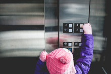 Young Girl Pressing Elevator Button 