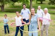 © WavebreakMediaMicro - Multi-generation family playing with hula hoop