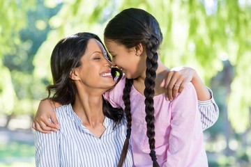 Mother embracing her daughter in park