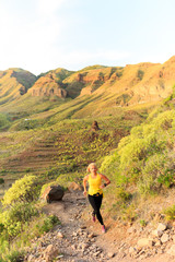 Young woman running on mountain trail