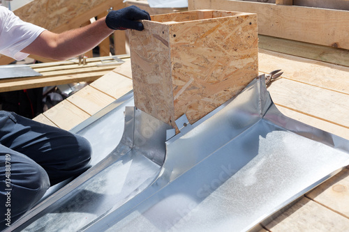 Fotografía Roofer builder worker attach metal sheet to the chimney
