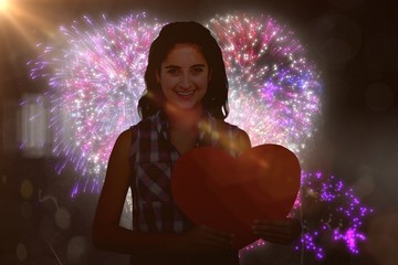 Poster - Composite image of portrait of smiling woman holding heart card